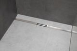 Grille d'évacuation de douche Geberit CleanLine30 en acier inoxydable brossé, 30-90 cm, installée sur un sol carrelé.