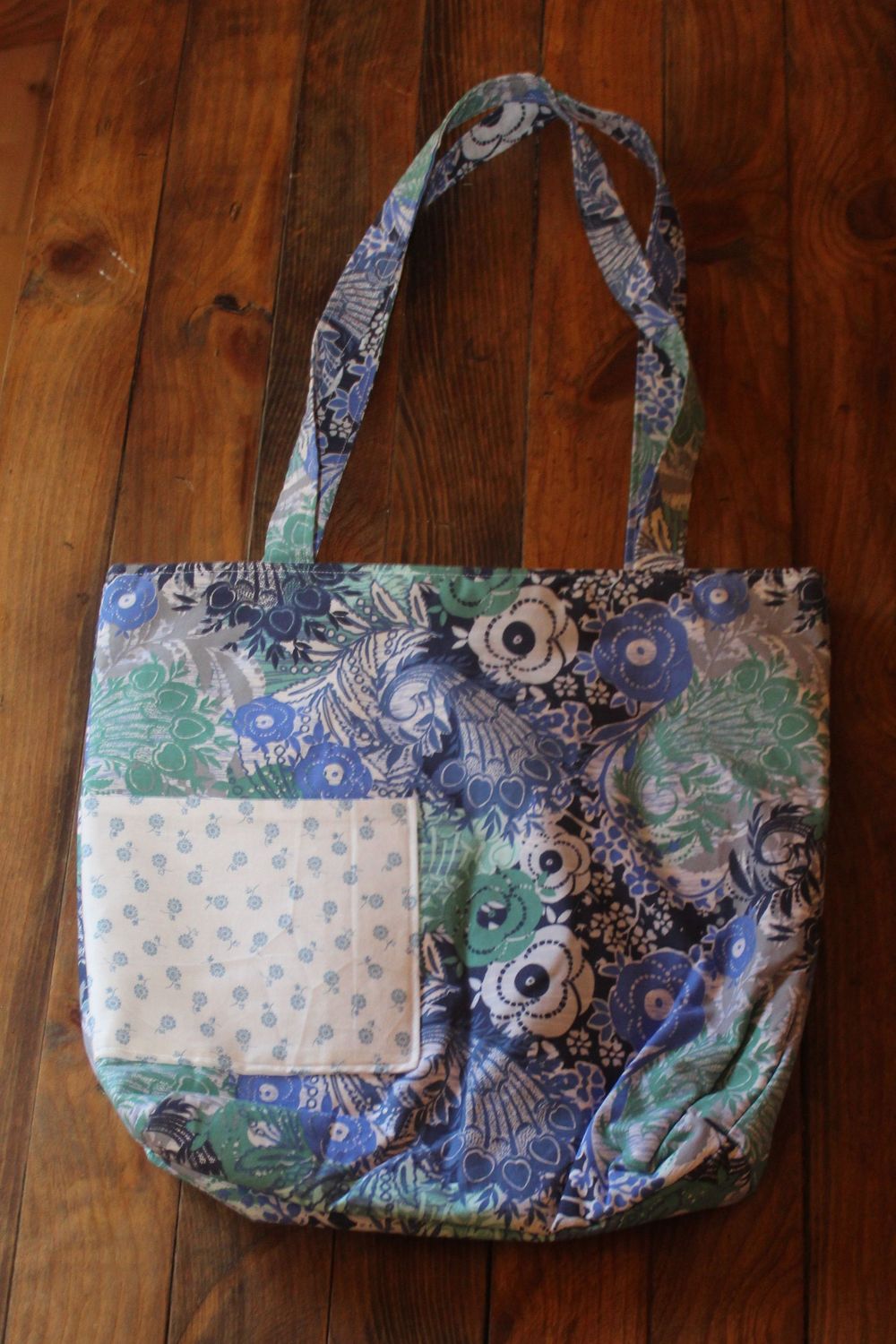 Handmade blue and green floral tote bag with front pocket.
