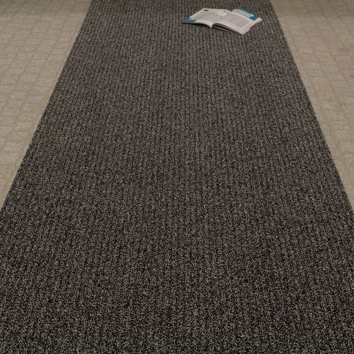 AKO Sicherheitsmatte Farbe Salz &amp; Pfeffer (Schwarz und Weiß). Auf dem Bild ist die Matte ausgerollt auf ebenem Untergrund.