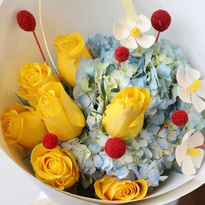 Yellow rose and blue hydrangea bouquet with playful red accents by W Floral Studio