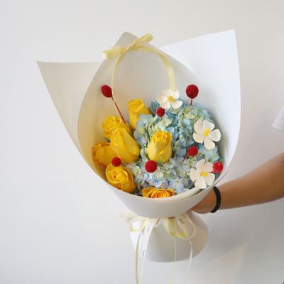 Princess-inspired bouquet with yellow roses, blue hydrangea and delicate white blooms