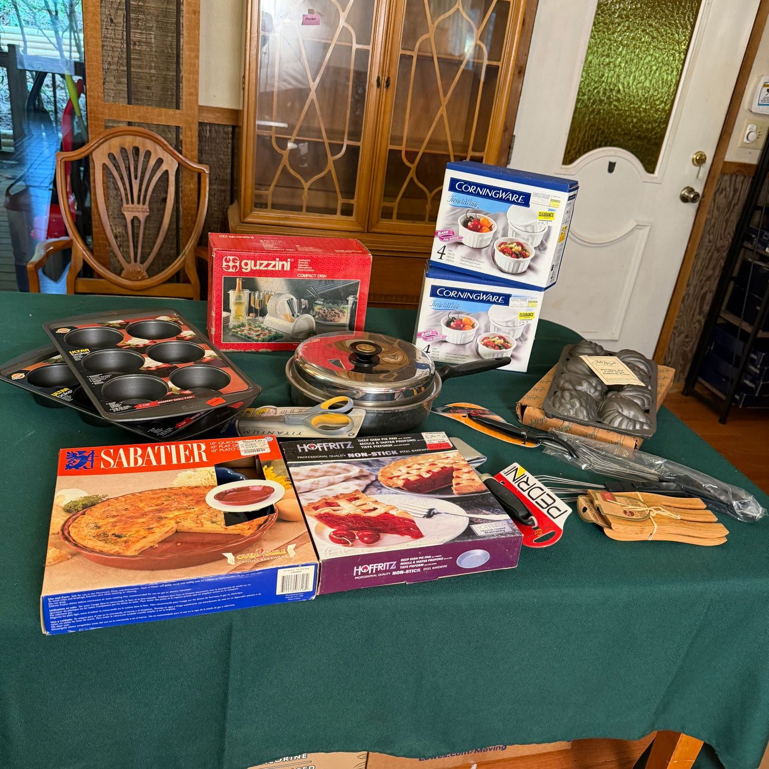 Kitchen box lot B0694 Guzzini dish rack, Wilton dessert shell pans, Corningware French White small stoneware cups, John Wright baking pan, pie pans, and more