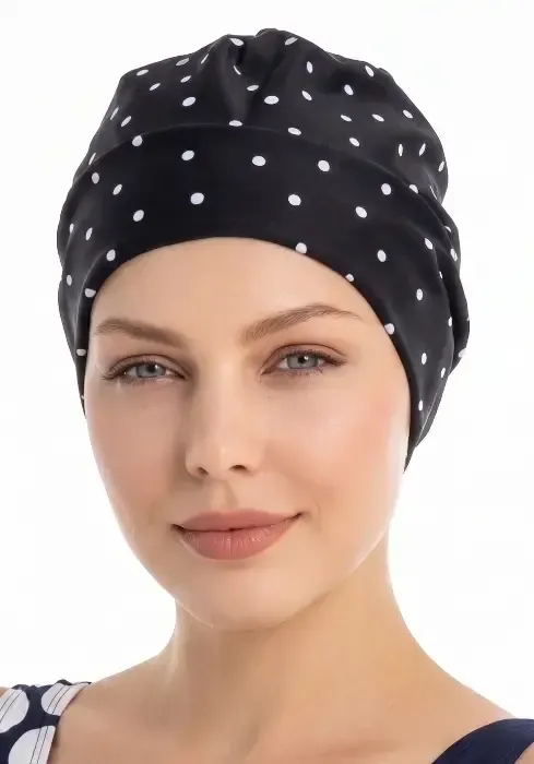Close up of a model wearing a Fashy Polka Dot Black Swim Cap & hot spots eco swimsuit