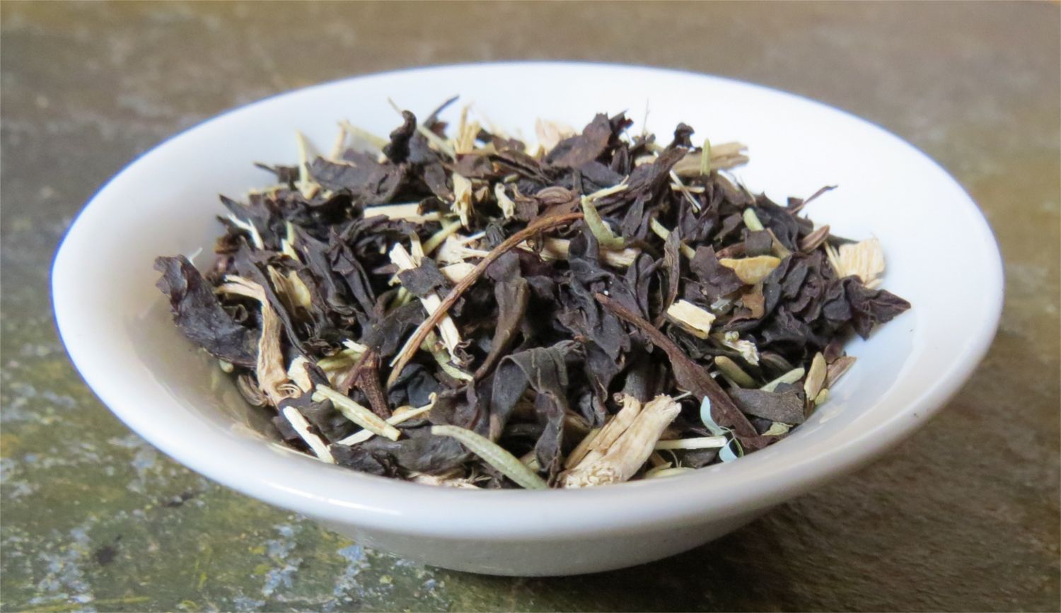 A small white bowl full of a blend of black tea, ginger, Oatstraw, and vanilla.