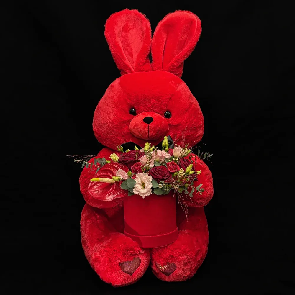 Adorable lapin rouge présentant une boîte de fleurs raffinée, création florale Saint-Valentin Fleurs de Prestige