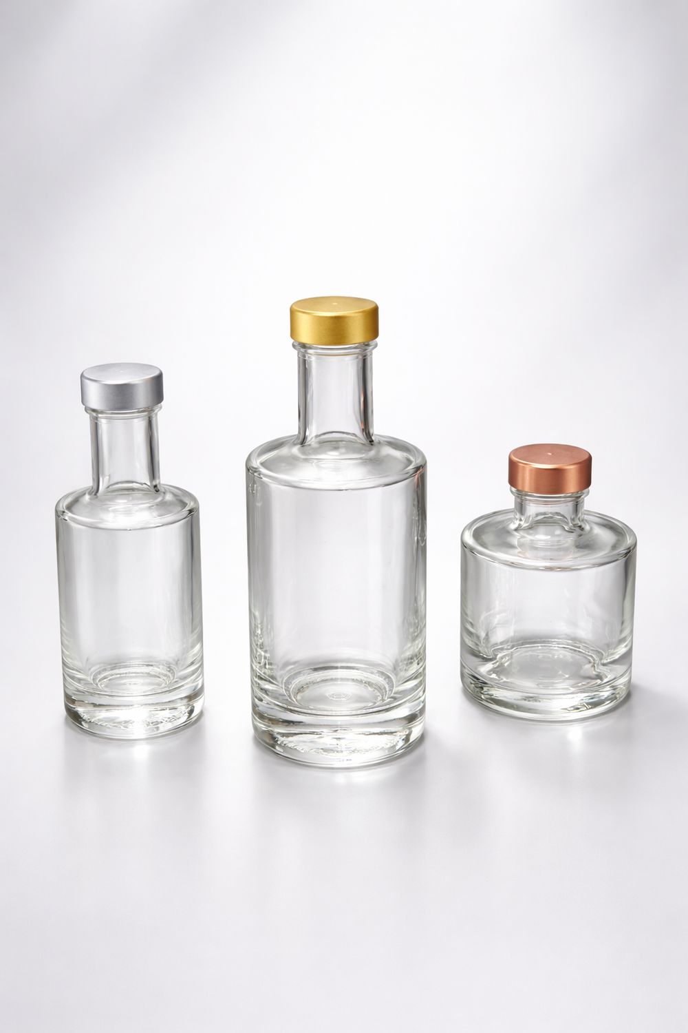 Likörflaschen aus klarem Glas mit Metallverschluss in Gold, Silber und Bronze in drei Größen