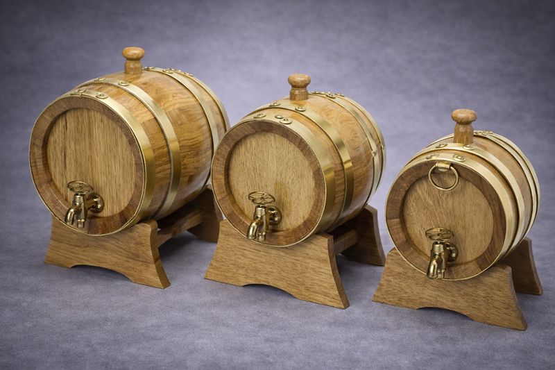 Eichenholzfass mit Messingbeschlägen und Zapfhahn auf Holzständer in mehreren Größen