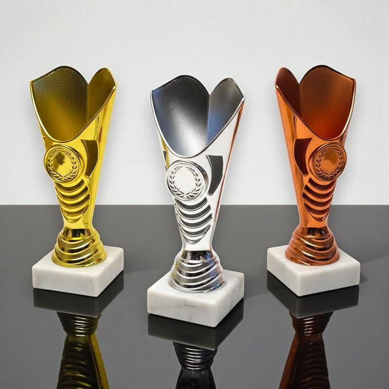 Pokaltrophäe aus Kunststoff auf weißem Marmorsockel in Gold, Silber und Bronze