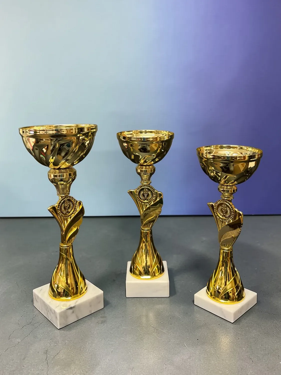 Pokal Pokal Rising Champion gold mit weißem Marmorsockel in drei Größen