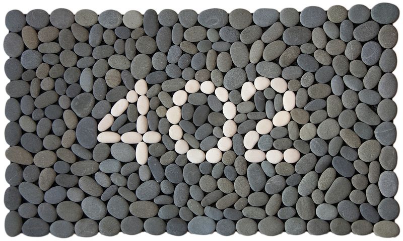 STREET NUMBER Stonemat featuring custom white stone numbers surrounded by natural grey stones in a handmade design