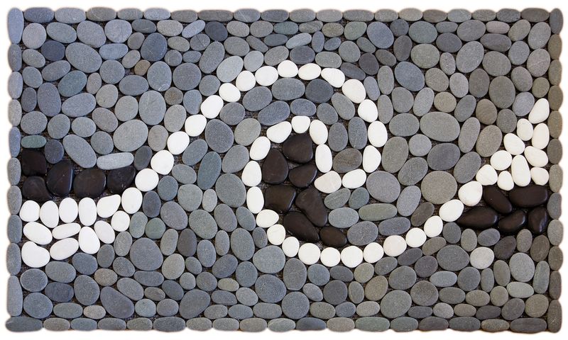 WAVE Stonemat featuring a single white stone wave with black stone detailing, surrounded by natural grey stones.