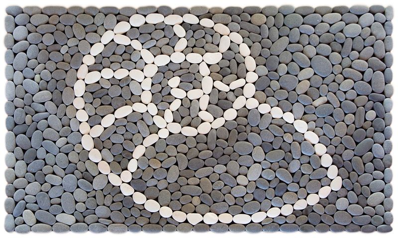 Handmade stonemat featuring a nautilus shell design in white stones surrounded by natural river stones