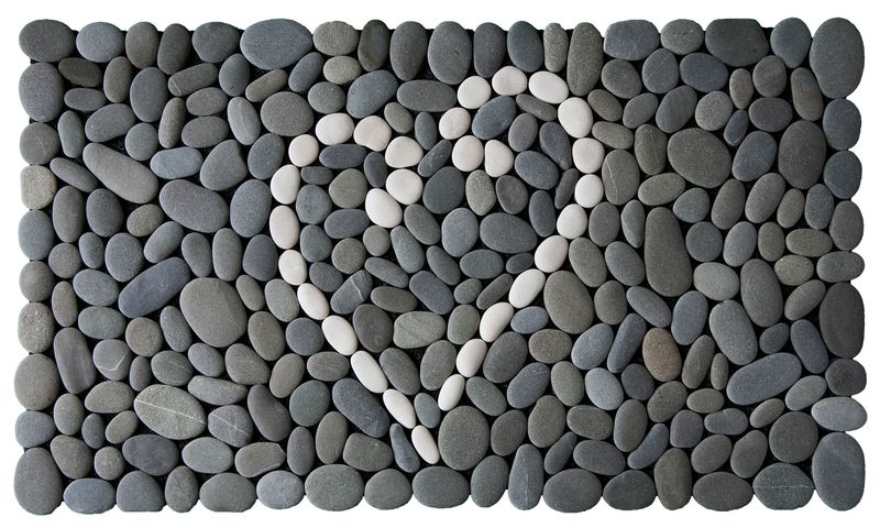 Koru Heart Stonemat featuring a heart shape made from two white koru spirals surrounded by natural grey stones