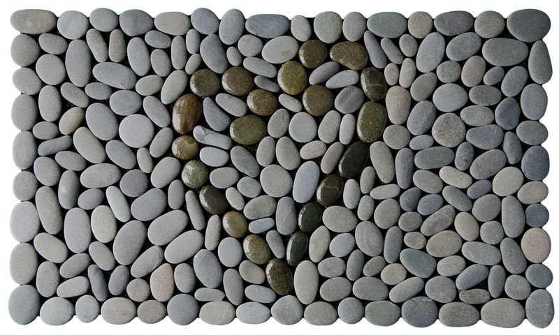 Koru Heart Stonemat featuring a heart shape made from dark polished koru spirals surrounded by natural grey stones