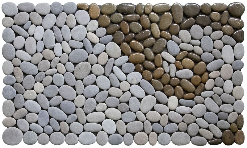 KORU OF THE LAND Stonemat featuring a natural grey koru spiral framed by polished dark stones in a handmade design