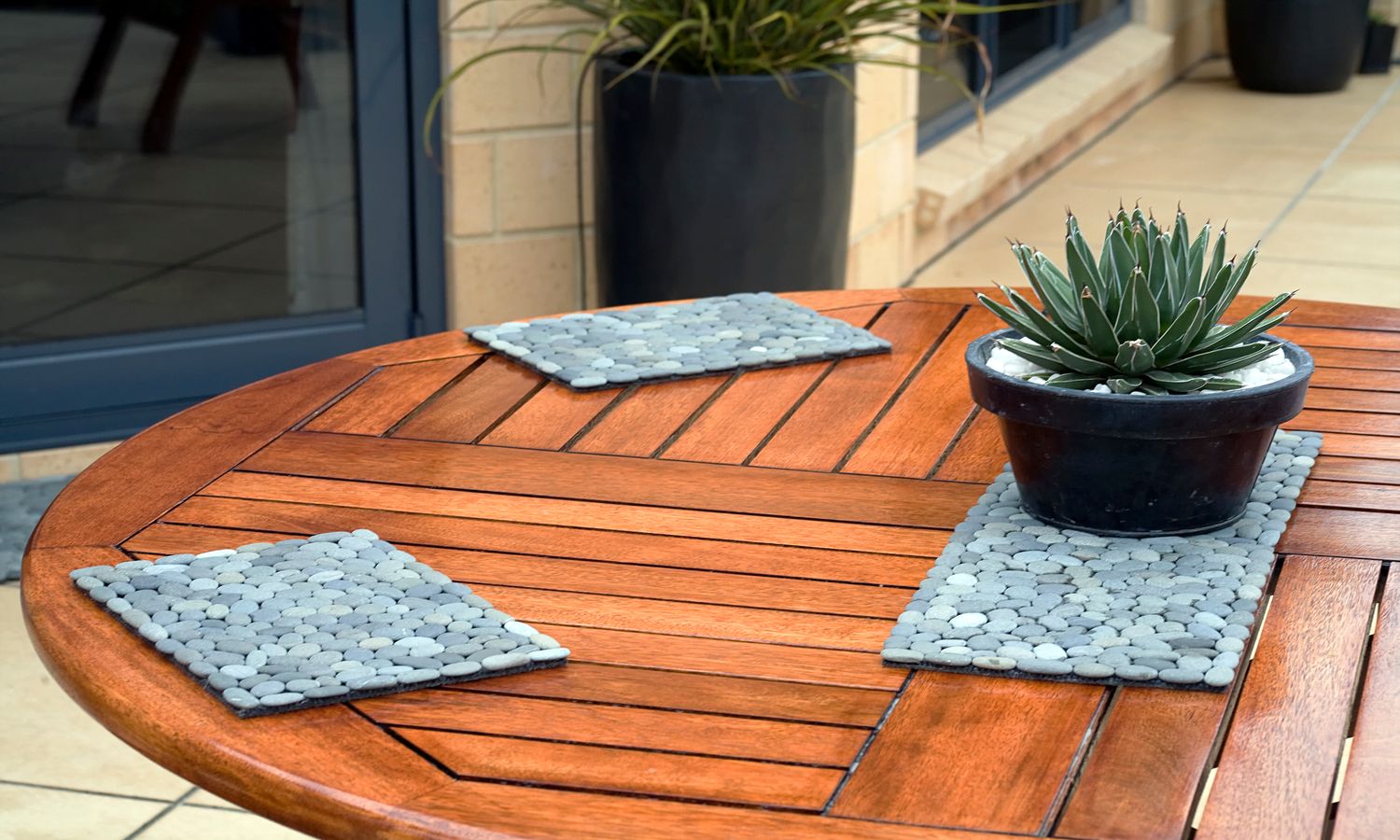Handmade placemats with natural grey stones on an outdoor dining table, adding elegance to patio dining