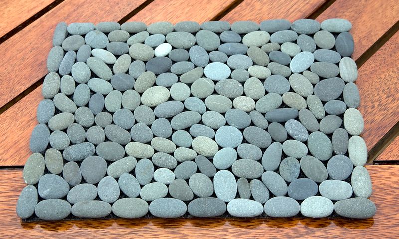 Handmade placemats with natural grey stones on an outdoor dining table, adding elegance to patio dining