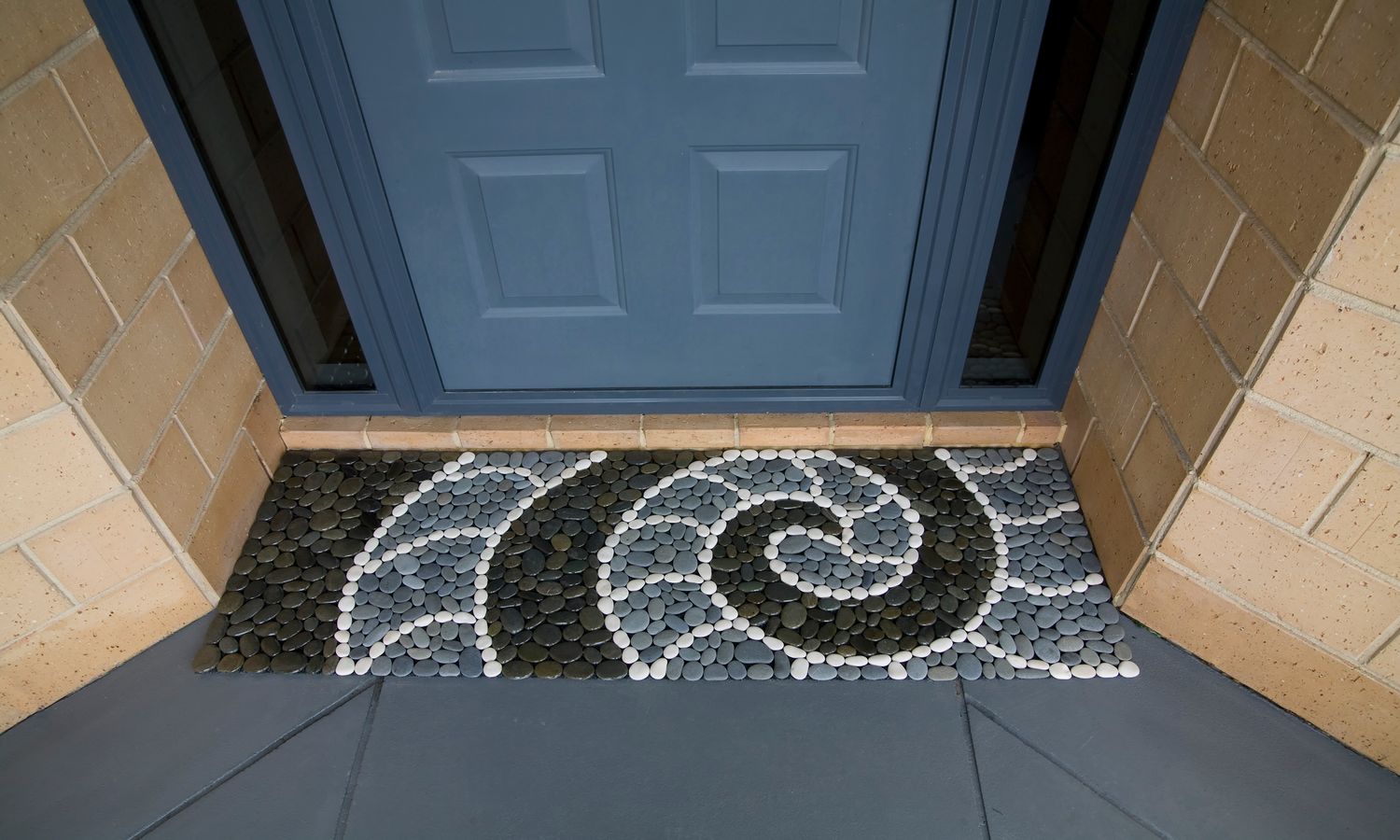 Handmade NAUTILUS KORU Stonemat combining a koru spiral and nautilus shell design with polished and natural river stones.