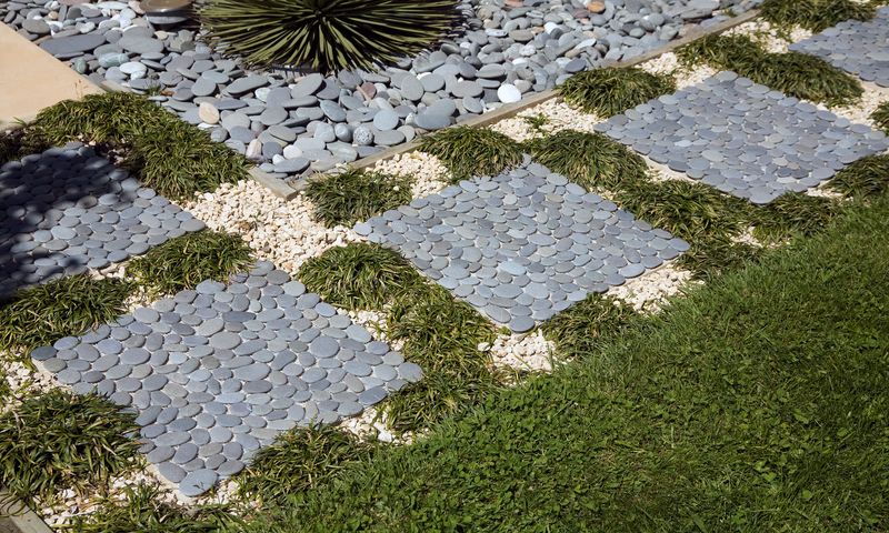 Custom paving design featuring natural grey stones in a random pattern with fiberglass mesh backing for grouting in place