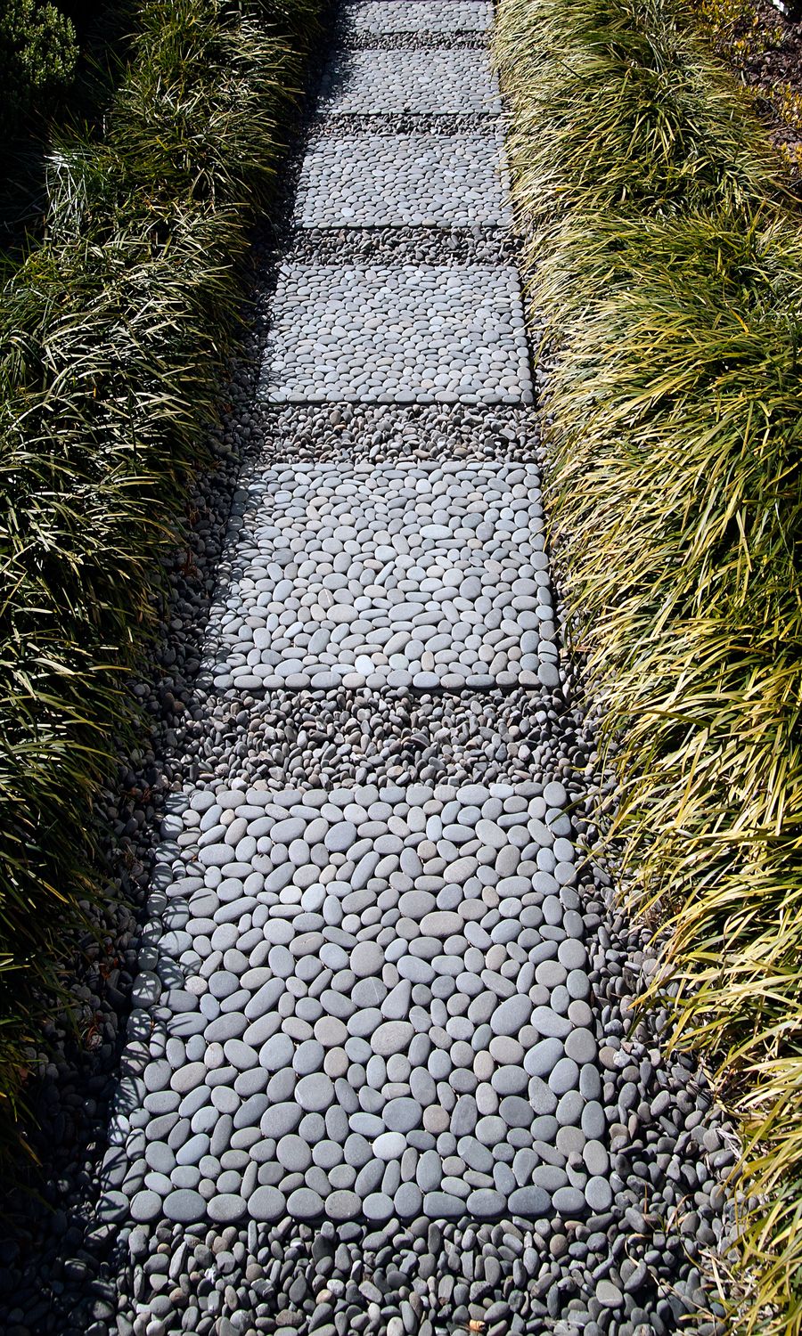 Custom paving design featuring natural grey stones in a random pattern with fiberglass mesh backing for grouting in place