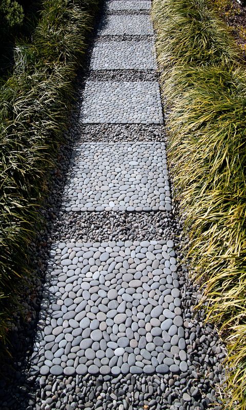 Custom paving design featuring natural grey stones in a random pattern with fiberglass mesh backing for grouting in place