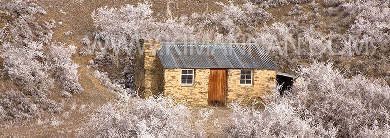 Historic stone cottage in Central Otago surrounded by hoar frost, capturing New Zealand’s serene winter beauty