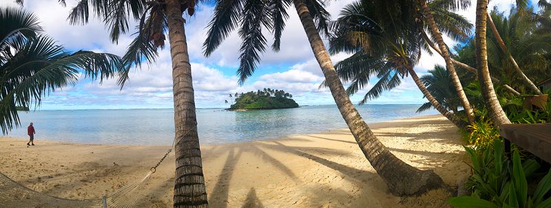 Rarotonga Muri Beach with an island in the background, flanked by palm trees