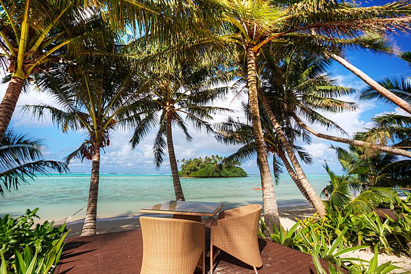 Table setting among palm trees overlooking Muri Beach