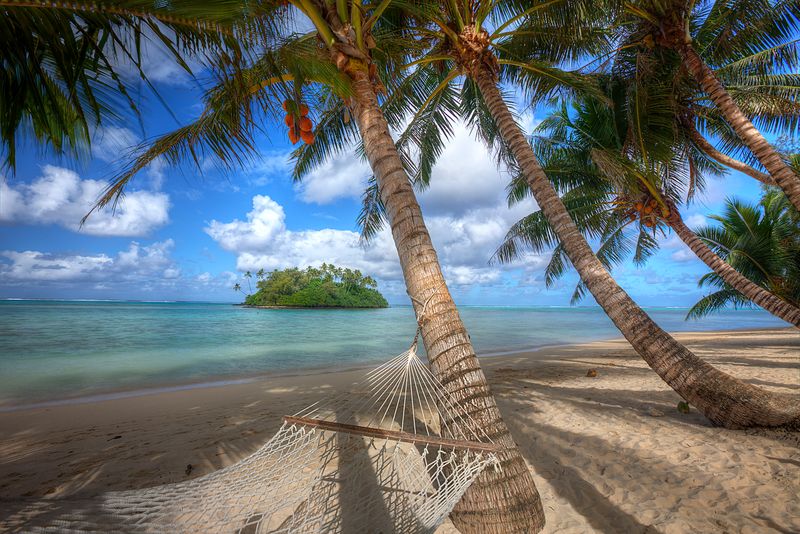 Hammock on Muri Beach surrounded by palm trees and turquoise waters