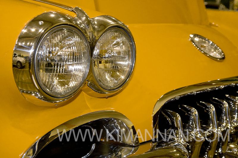 Close-up of the headlights and grill of a Yellow Mustang Classic Car