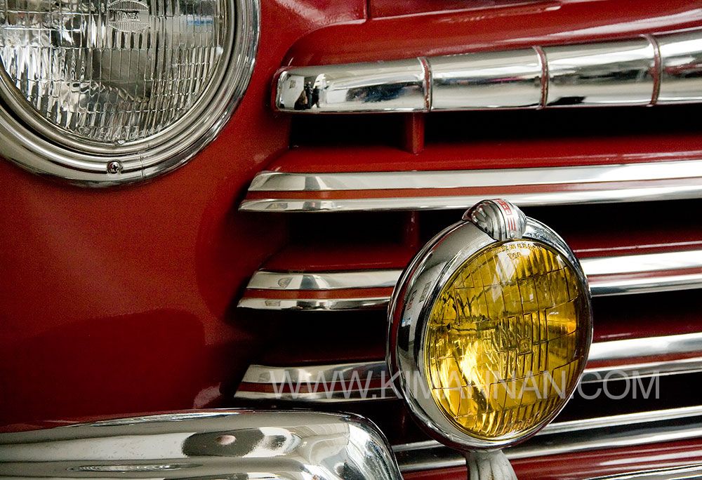 Close-up of the front grill and headlights of a Ford Super DeLuxe in Pheasant Red