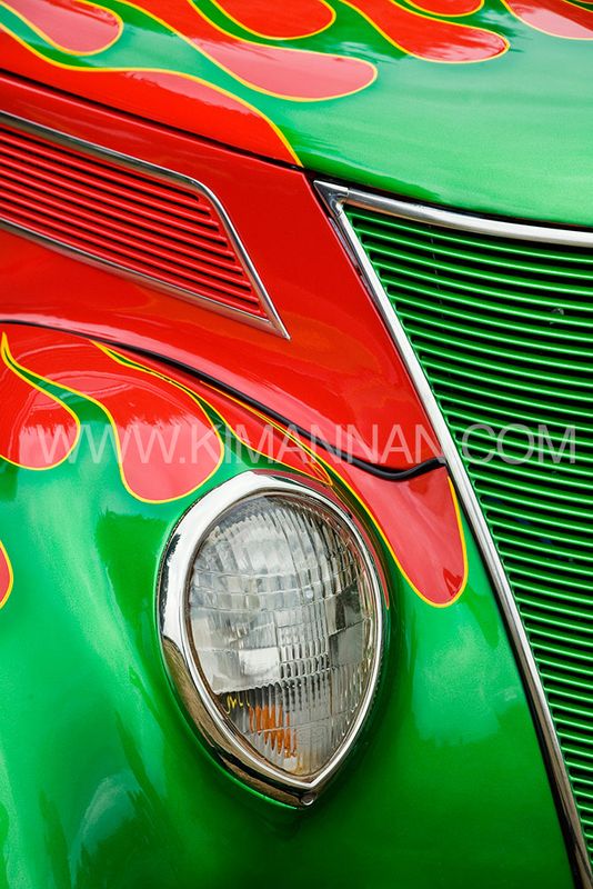 Close-up of the flame design on the body of a Ford Sedan Hot Rod near the front light and grill