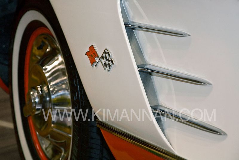 Close-up of the fins on the back right side of an orange and white 1958 Chevrolet Corvette
