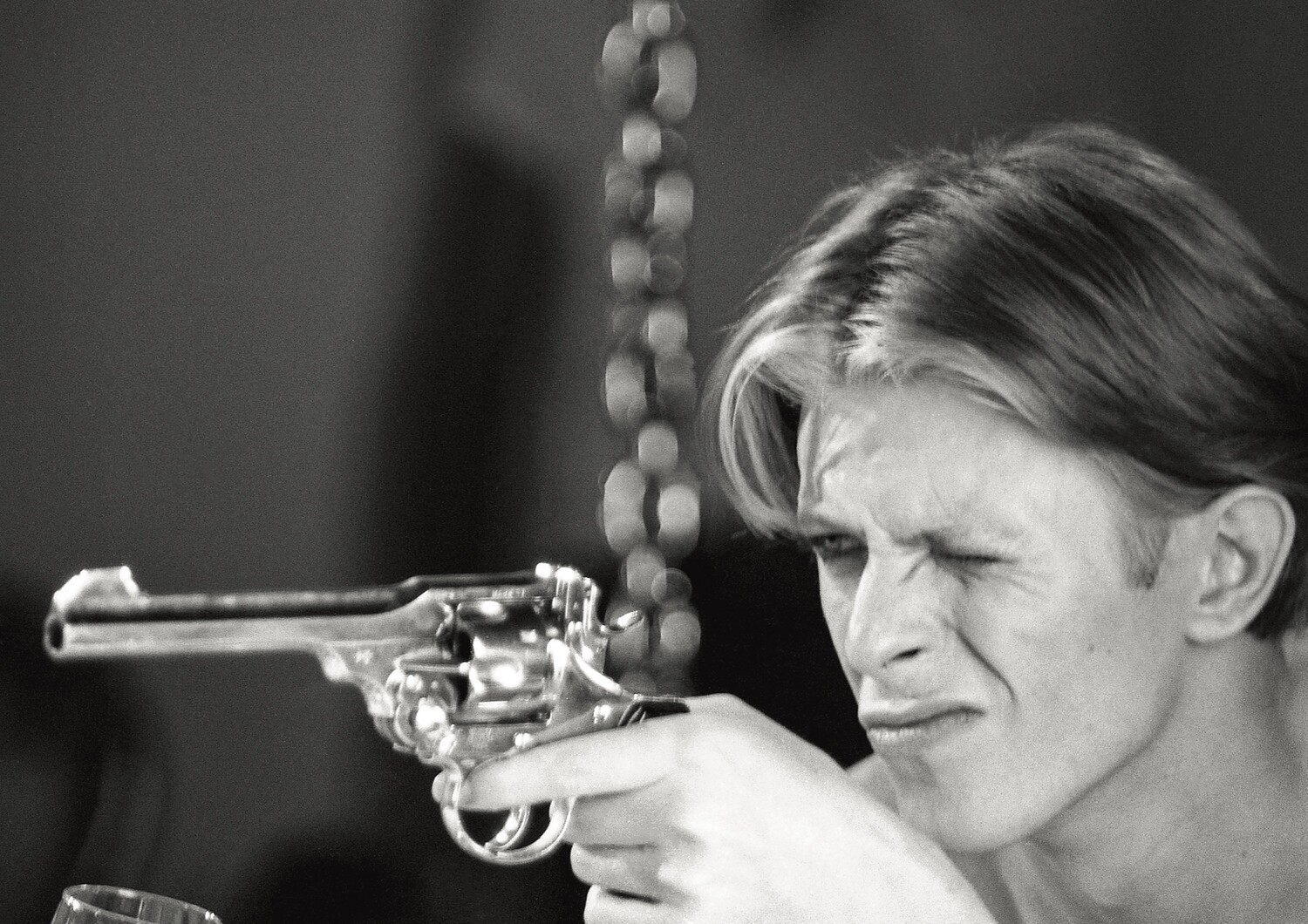 David Bowie:  TMWFTE, on set with pistol, 1975 - MAC054
