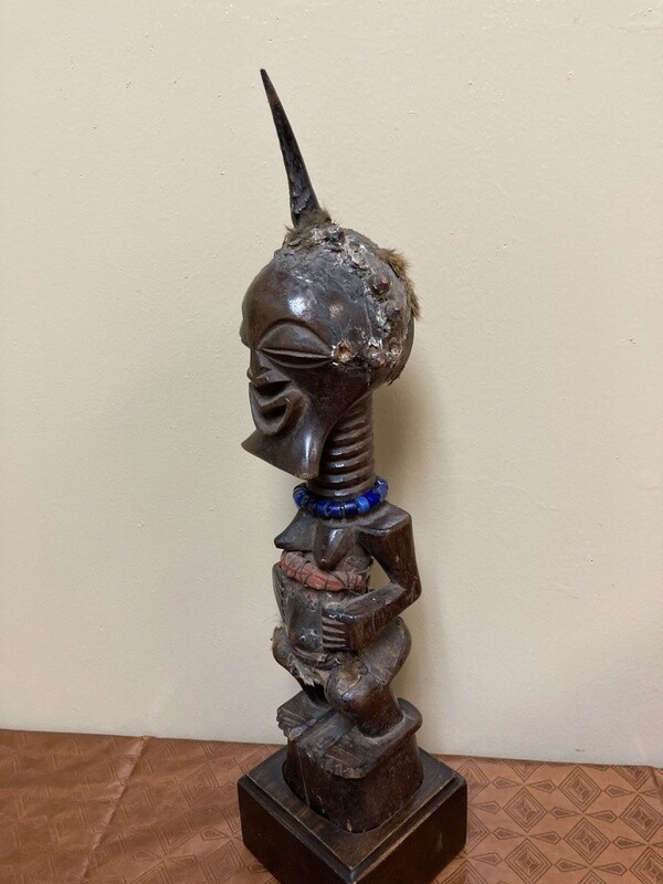 Songye or Basonge wooden figure: This fine figure had the job of protection. It&#39;s wooden with horn , blue beads or cotton fabric. The sculpture is 17 5/8&quot; h including the base. The Songye are found in