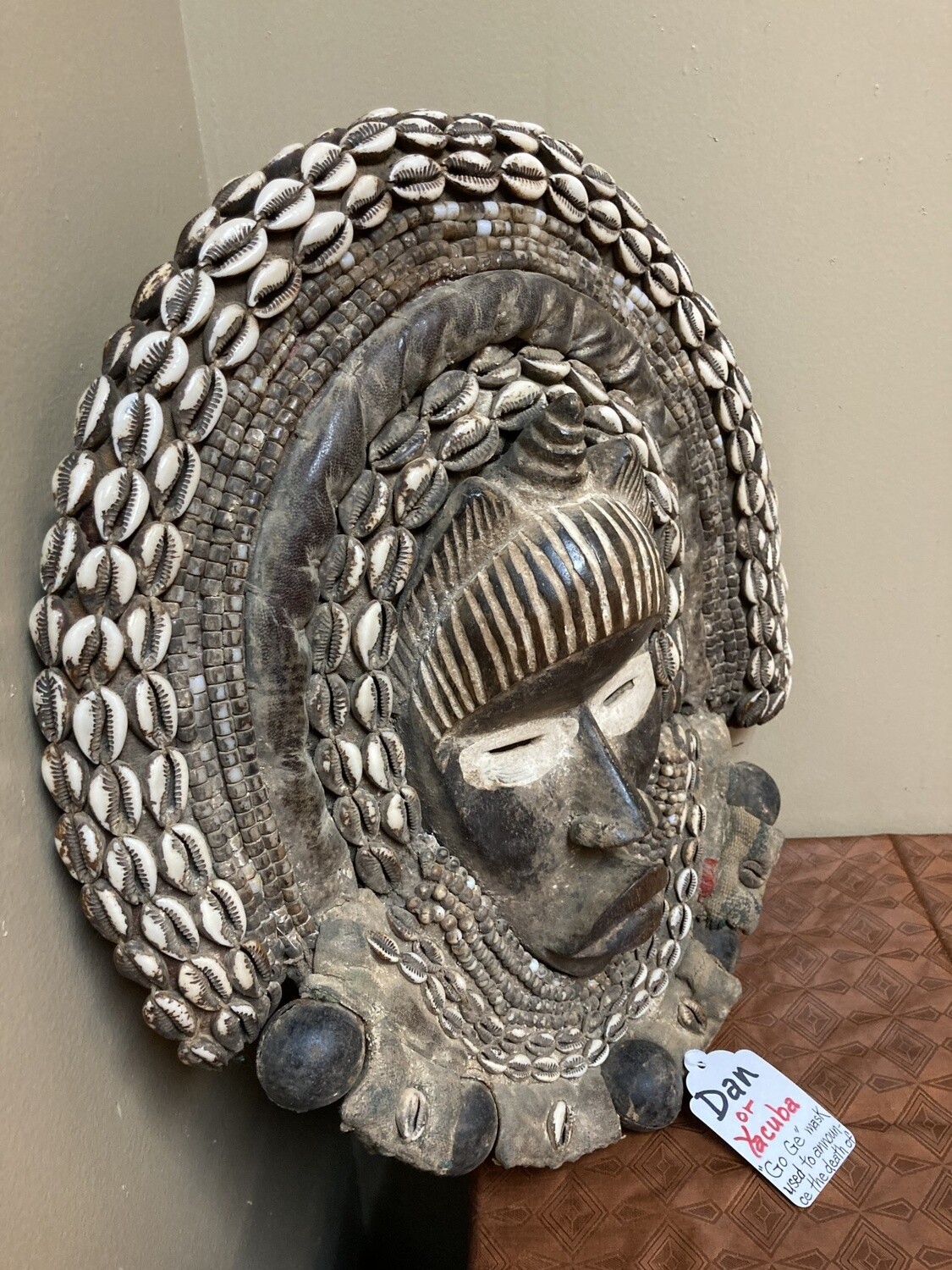 Dan (Yacuba) &quot;Go Ge&quot; mask: The job of this mask is to announce the death of the chief. The dan are found in SW ivory coast and next door in Liberia. Wood, cowrie shells, fabric, and kaolin (white colo