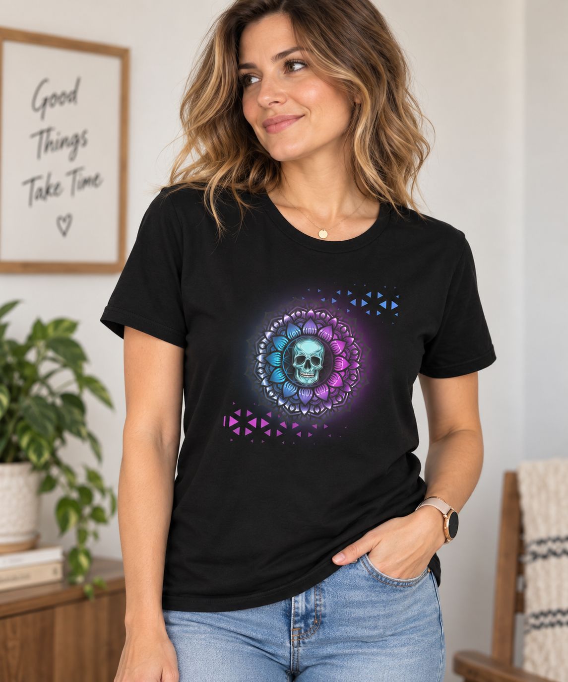 Woman wearing a black T-shirt featuring a vibrant blue and purple skull mandala graphic, styled with light-wash jeans