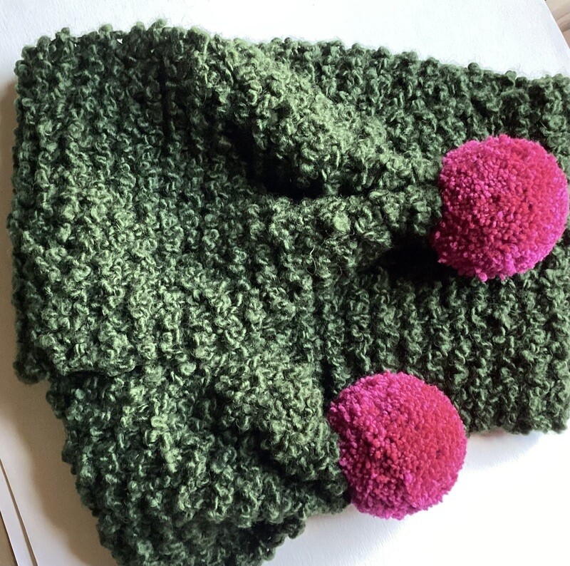 Luxurious wool bouclé scarf with cerise pompoms.