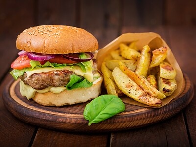 Burger with French Fry, Cheese, Tomato, and Red Onion on Wooden Table