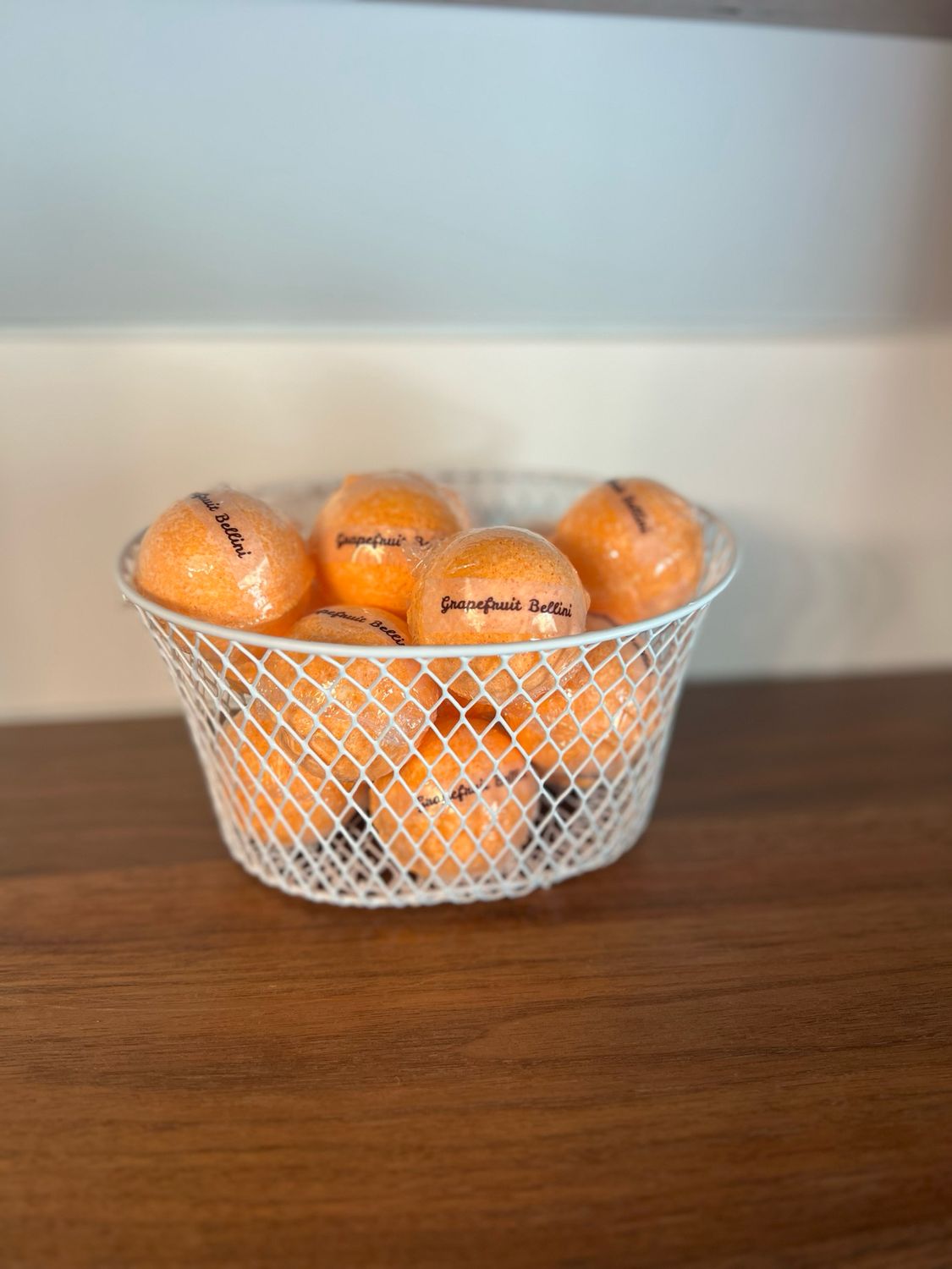 A white basket filled with orange bath bombs