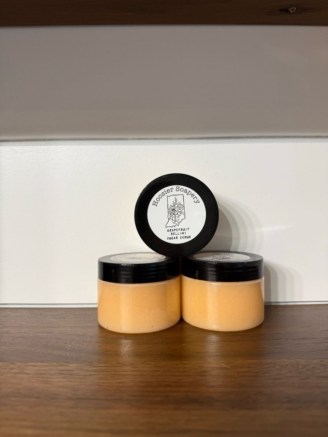 tan colored sugar scrub in a clear 4 ounce jar with black lid