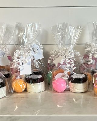 Bath bomb, body butter and soap bar featured in a clear bag with white ribbon