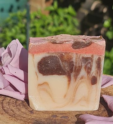 Handcrafted marbled soap bar with brown, cream, and pinkish-red layers, all-natural ingredients, displayed with pink rose petals—perfect for sensitive skin.&quot;