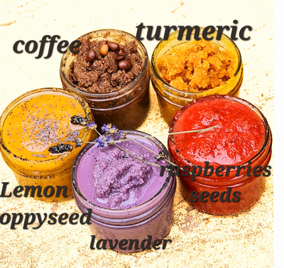 Set of five colorful natural sugar scrubs in glass jars, featuring coffee, turmeric, lemon &amp; poppyseed, lavender, and raspberry seed variants, arranged on a textured background with text labels identifying each scent.
