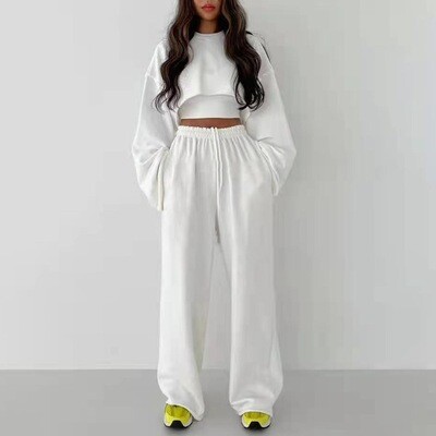 Kvinde i hvid TrendyTrio sweaterdragt med brede ben for et stilrent udseende