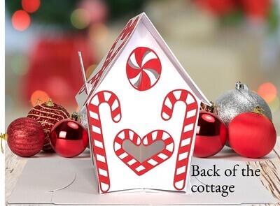 Finished 3D SVG Cricut project of a pop-up Christmas house decorated with candy canes and an LED tealight inside the door to make it glow.  This decoration is part of the Christmas Treat Village set by Bella Carta Design.