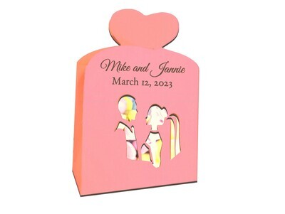 DIY wedding favor box made with a 3D SVG template and a Cricut, Silhouette or other cutting machine. The favor box features the cutout silhouette of bride and groom and measures 4 X 3 X 2.  It can hold several pieces of candy or other wedding favors for guests. Two hearts at the top of the bag fit together as a closure.