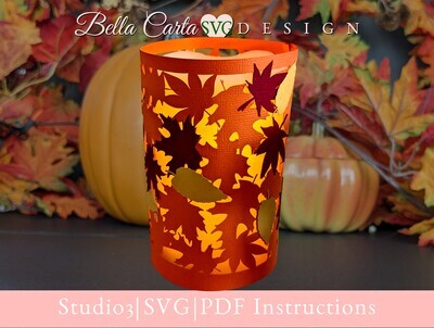 DIY paper lantern for an LED Pillar candle with colorful fall leaves all around it.