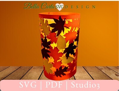 DIY paper lantern for an LED Pillar candle with colorful fall leaves all around it.