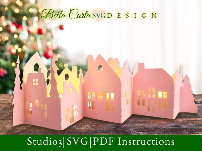 DIY holiday centerpiece made of cardstock that resembles a snowy village with pine trees.